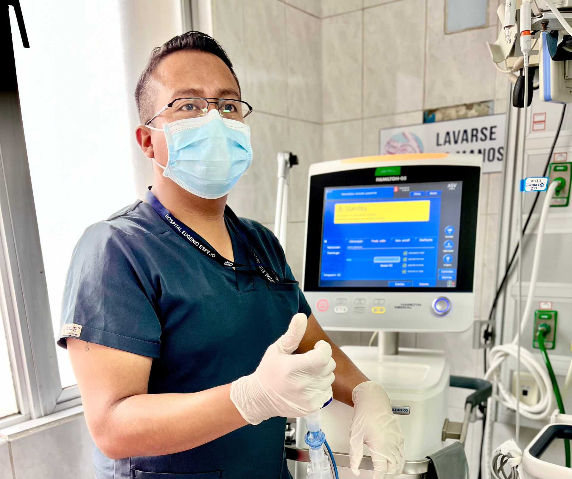 Lcdo. Danny junto a un ventilador mecánico en UCI
